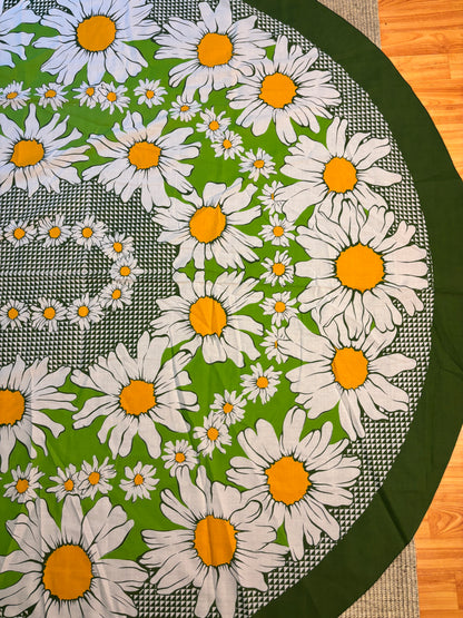 Round tablecloth with white daisy pattern on a green background