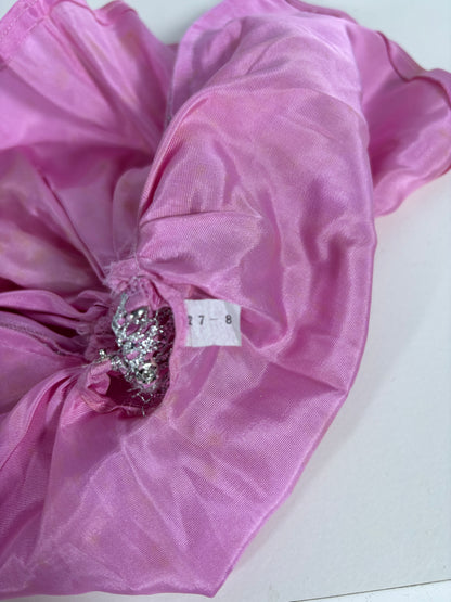 A close-up of a pink sheer fabric accessory, likely a hair scrunchie or gathered fabric piece, featuring a silver rhinestone embellishment and a small white size tag reading '27-8'.