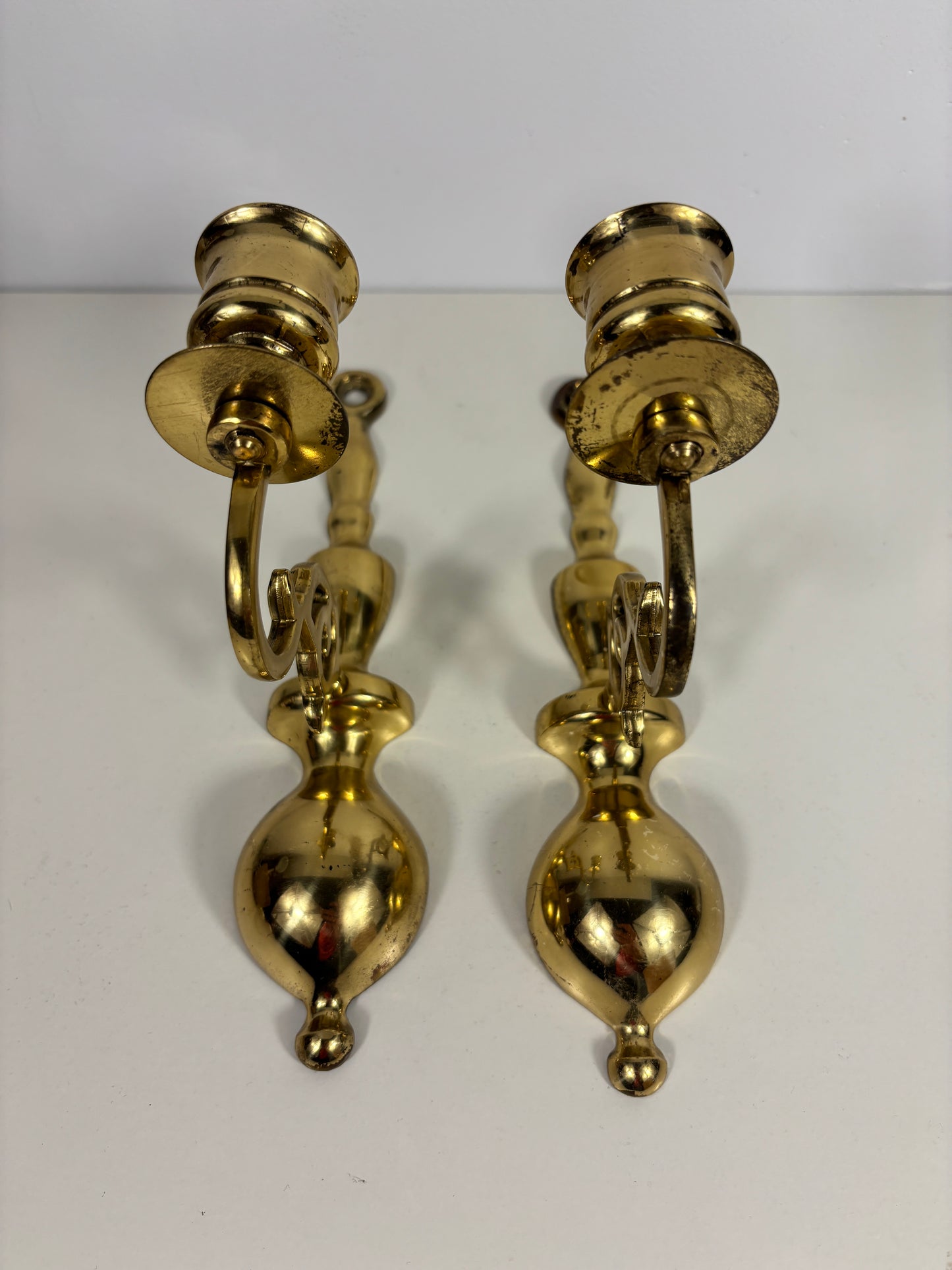 A pair of vintage brass wall sconces with bulb holders, displayed against a plain white background.