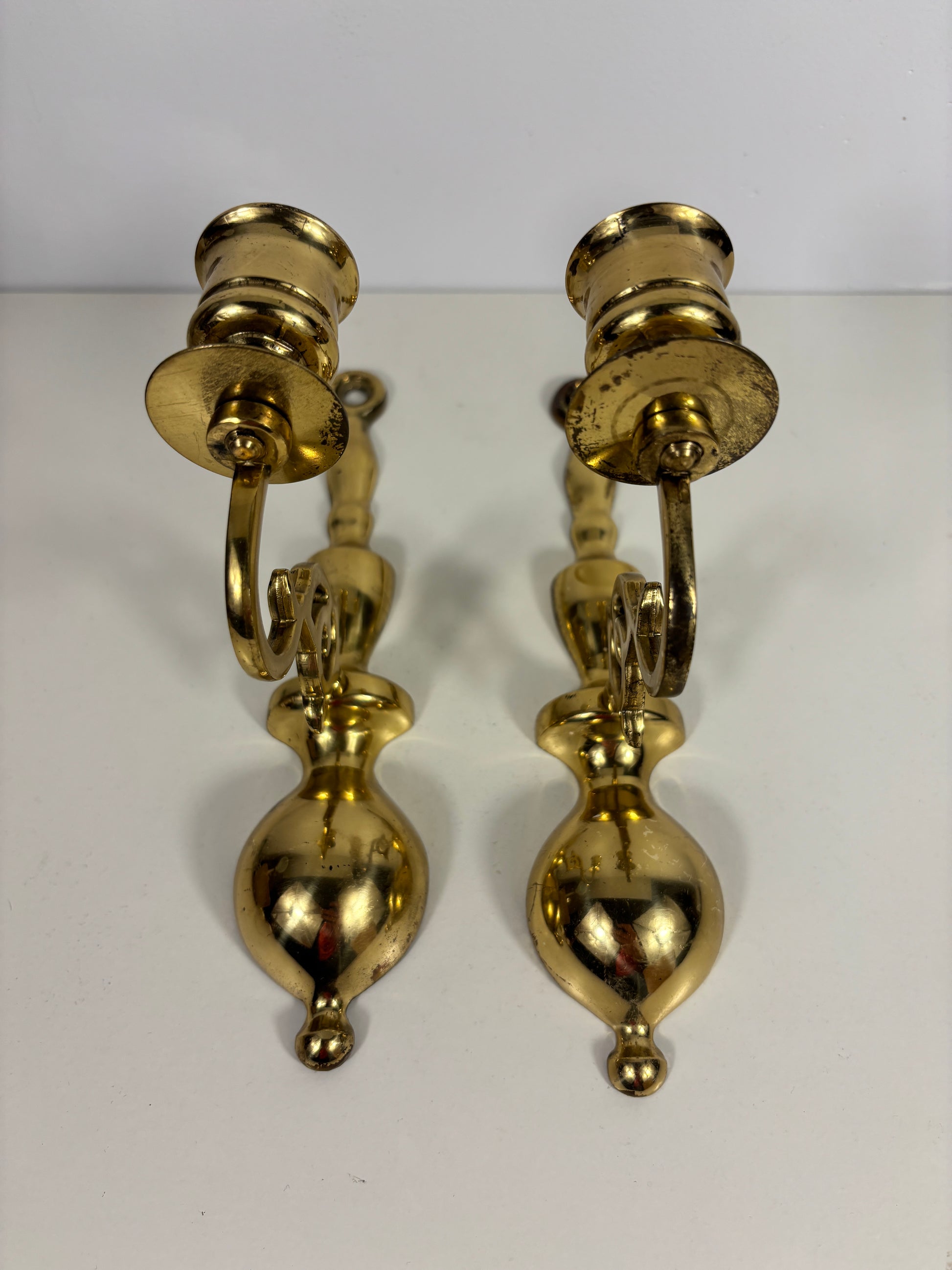 A pair of vintage brass wall sconces with bulb holders, displayed against a plain white background.