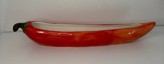 Ceramic bowl shaped like a red pepper on a white background