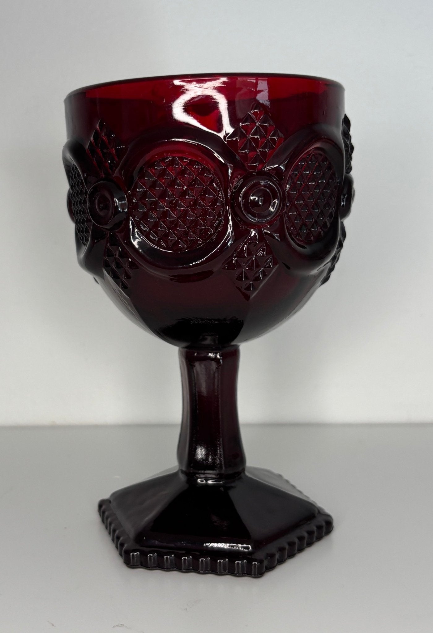 Red glass goblet with design on a white background