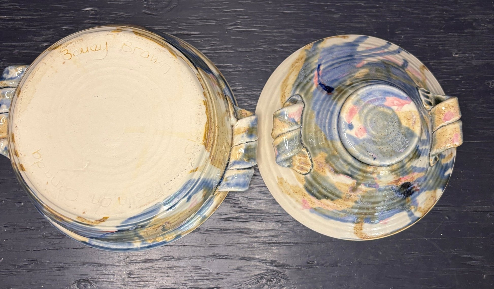 Two ceramic bowls with abstract patterns on a dark wooden surface