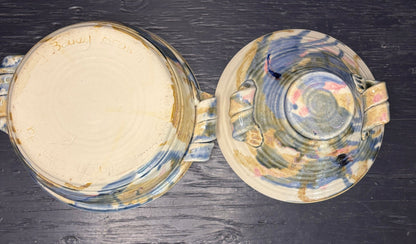 Two ceramic bowls with abstract patterns on a dark wooden surface