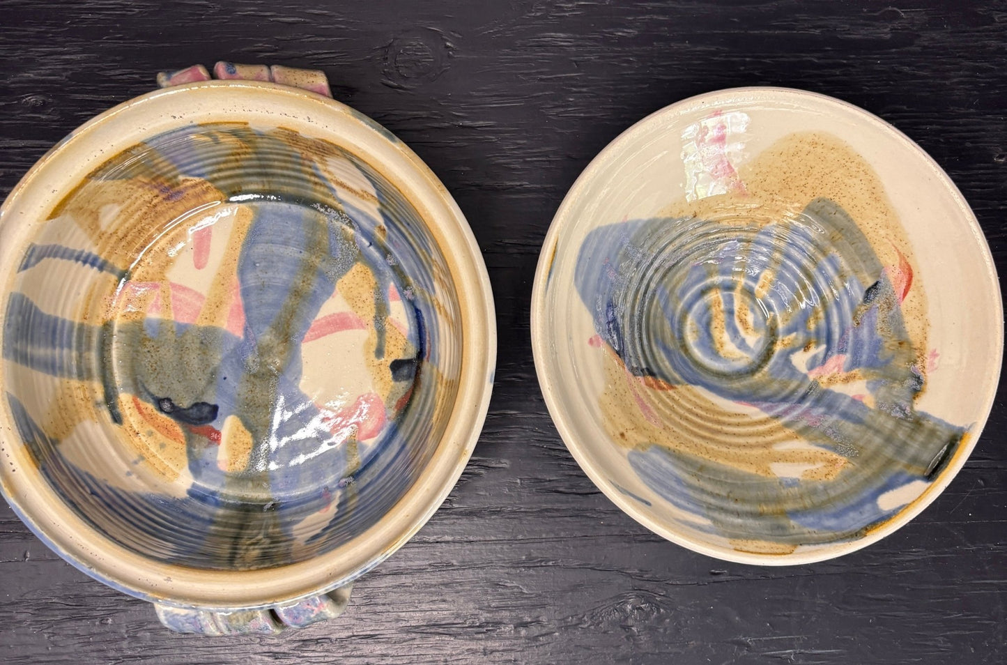 Two ceramic bowls with textured surfaces on a dark surface