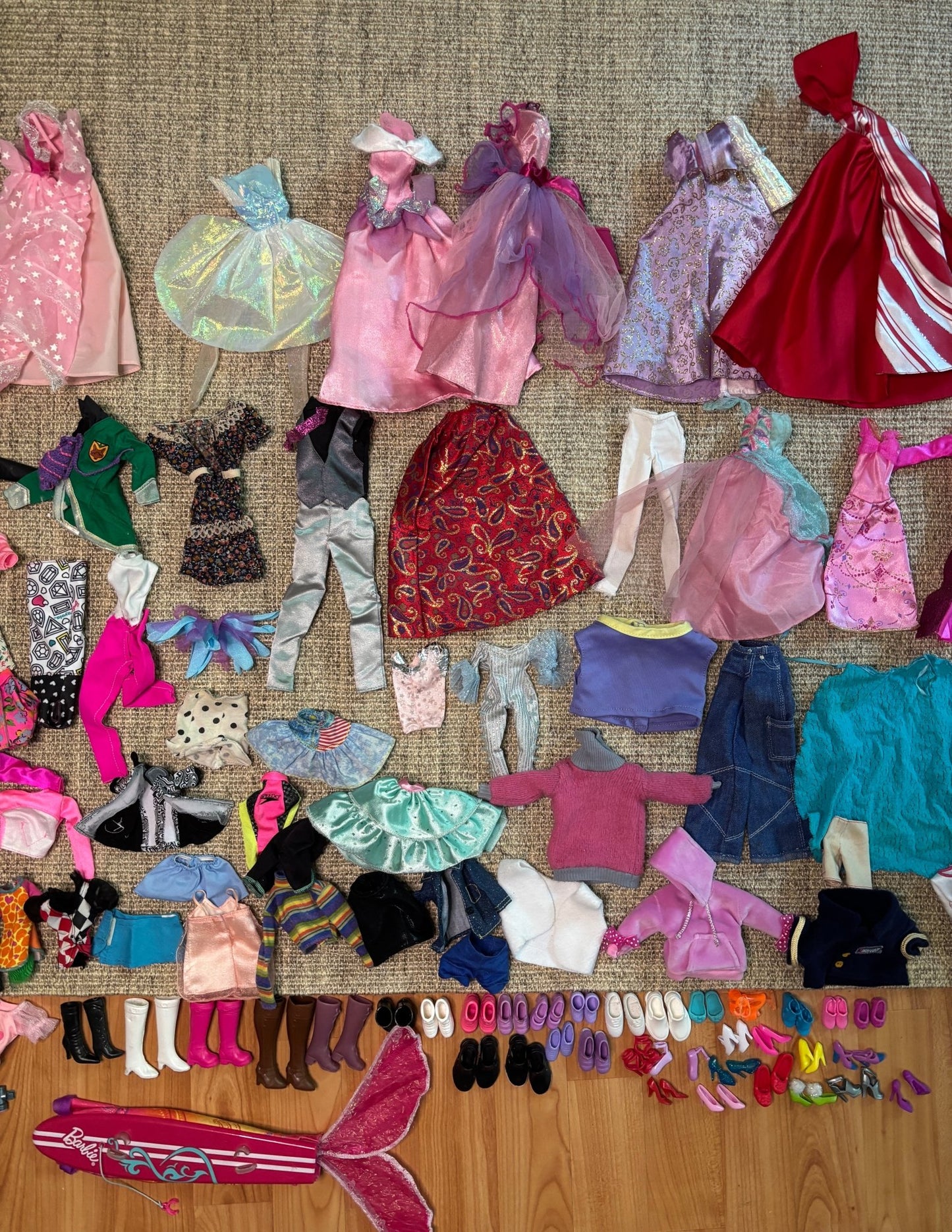 Collection of vintage doll clothes and accessories on a textured surface