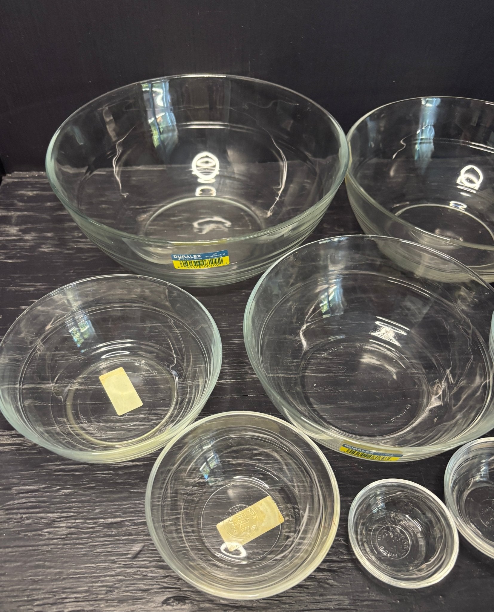 Set of clear glass bowls on a dark surface