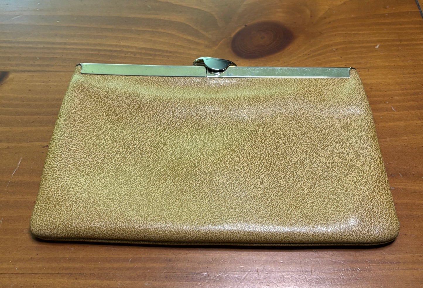 Gold clutch purse on a wooden surface