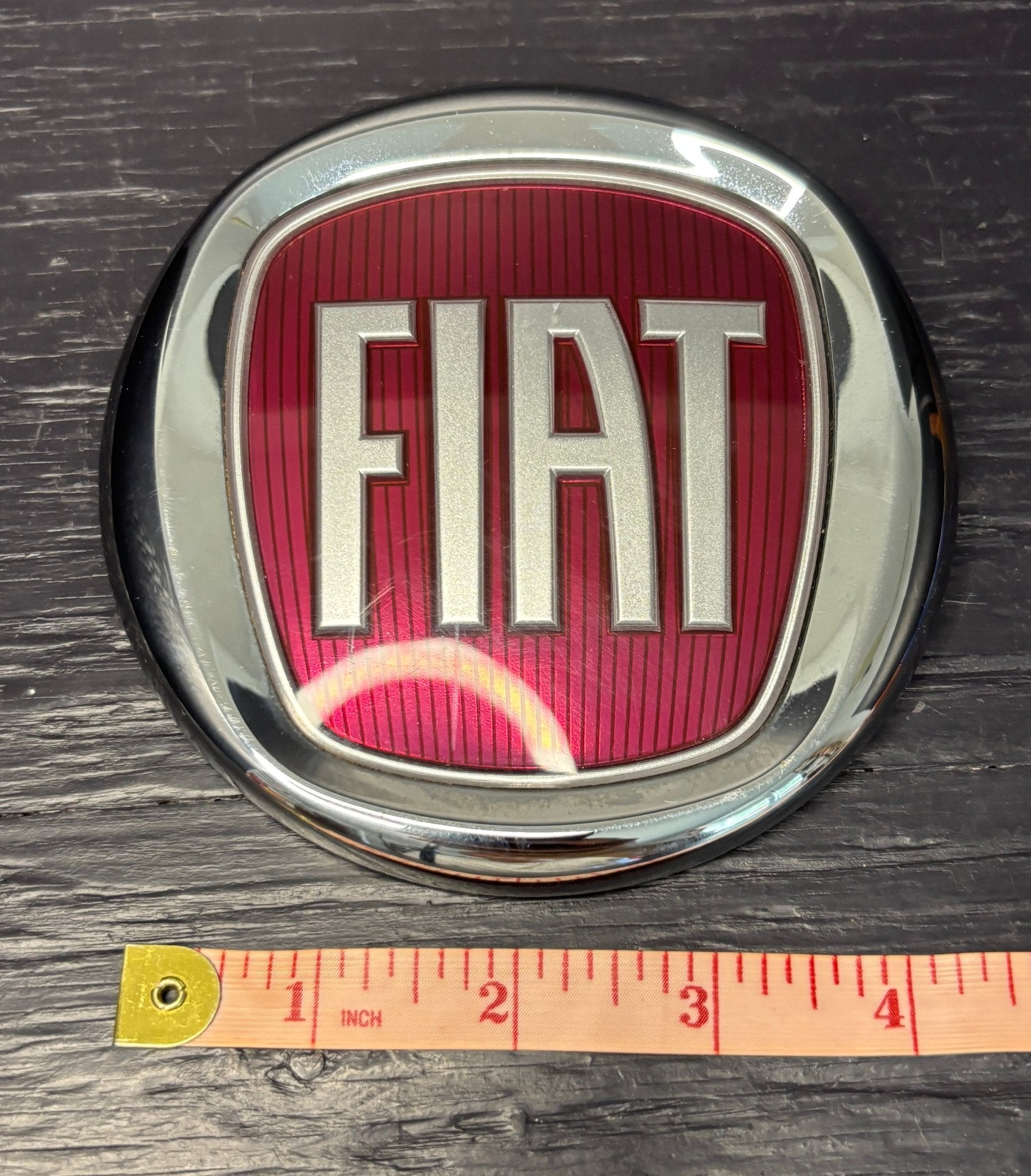 FIAT logo on a metallic background with a ruler for scale.