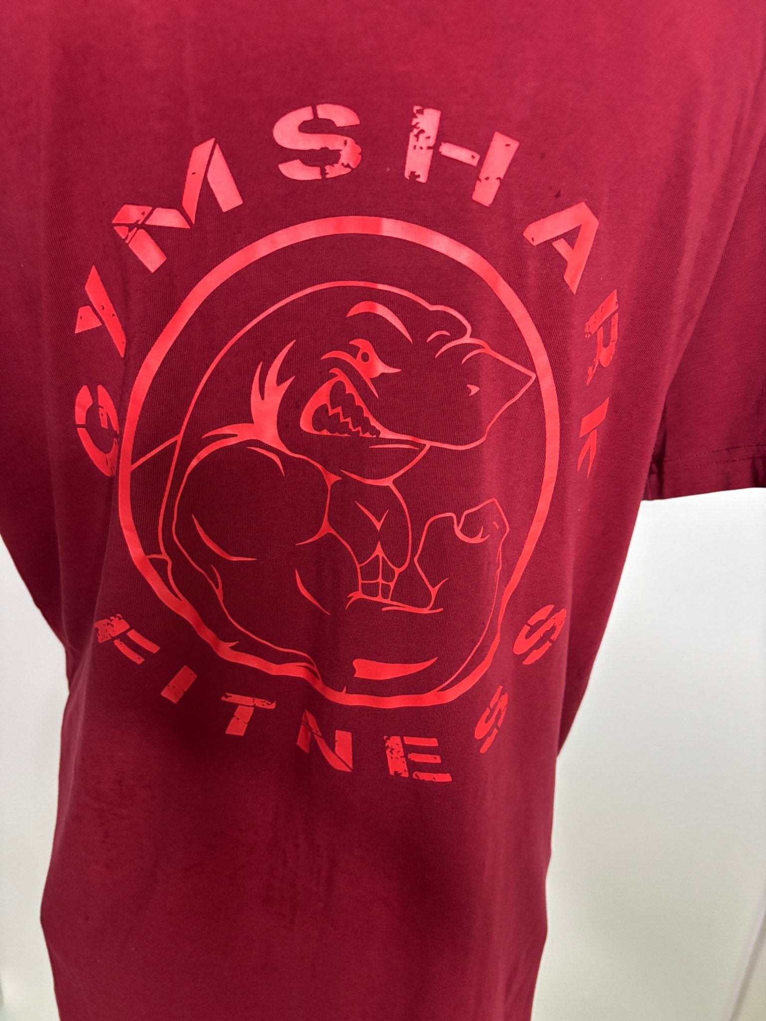 Maroon shirt with red graphic design and text on a white background