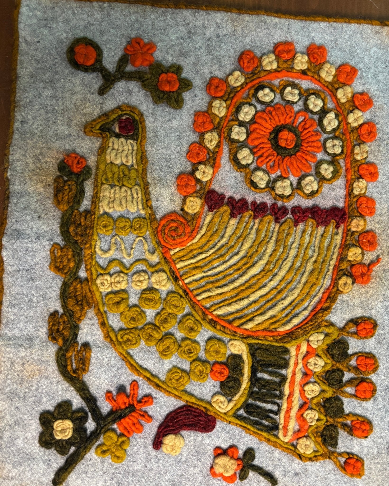 Decorative peacock design with flowers on a textured surface
