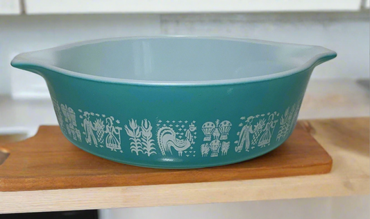 blue pyrex casserole dish with images of ladies and men farming