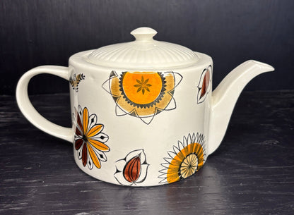 Ceramic teapot with floral patterns on a dark surface