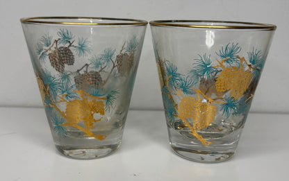Two glass tumblers with deer and pine cone design on a white background