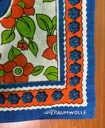 Fabric with floral pattern and blue border on a wooden surface