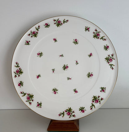 Decorative plate with floral pattern on a stand against a white background