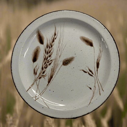 Ceramic plate with brown leaf design on a white background