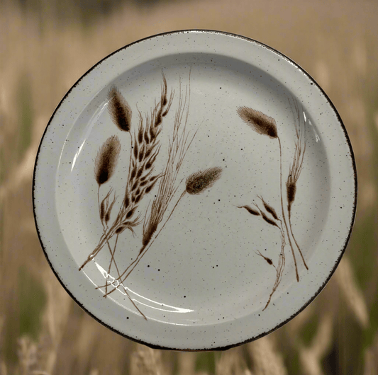 Ceramic plate with brown leaf design on a white background
