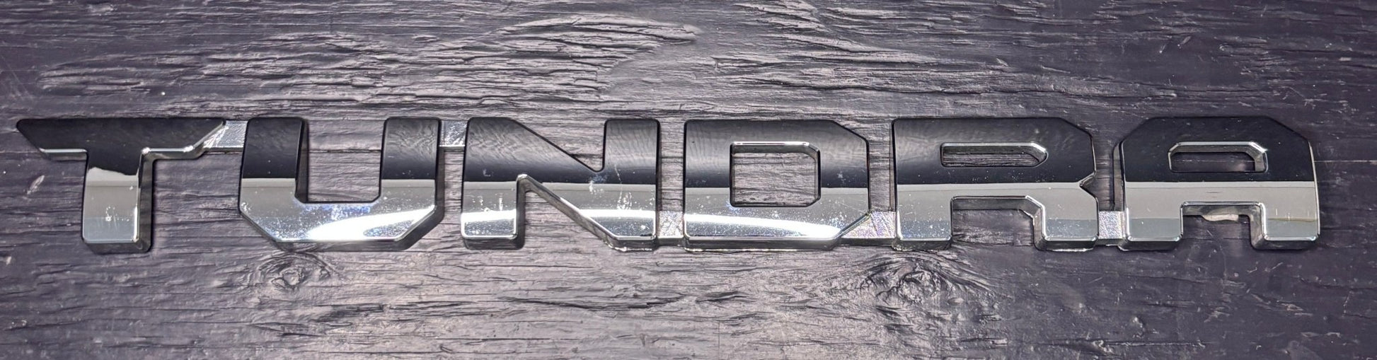 Metallic 'TUNDRA' logo on a textured surface