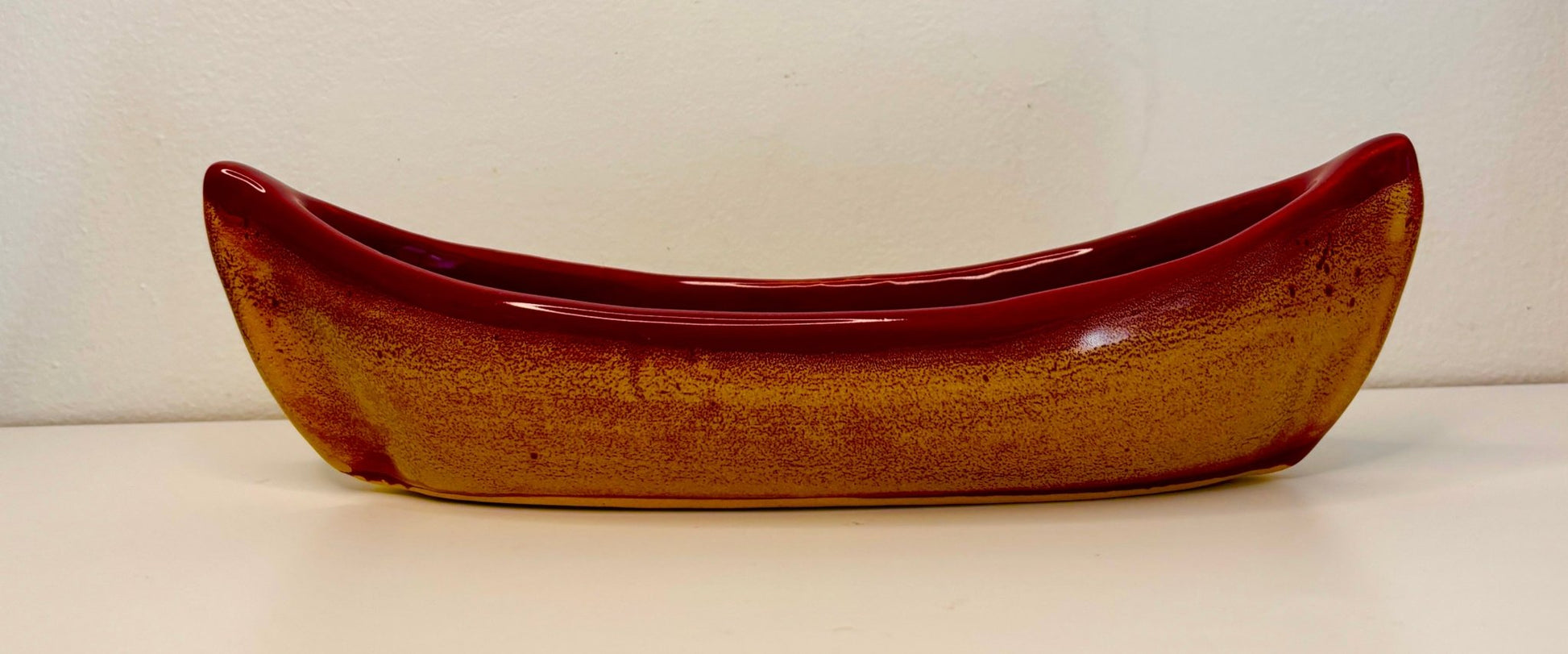 Ceramic canoe-shaped bowl on a white background